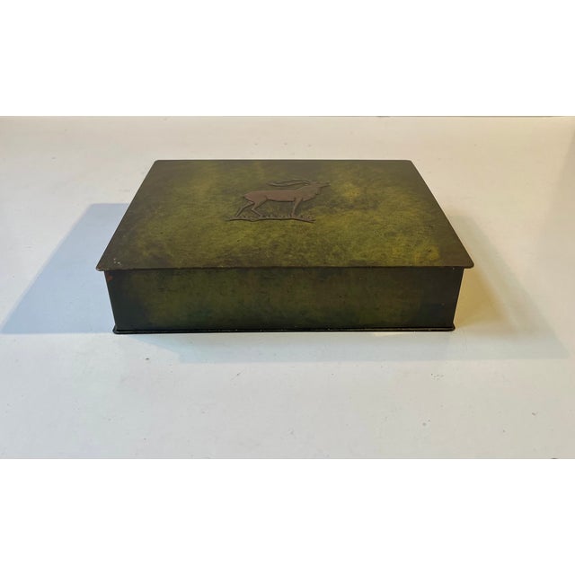 Decorative Bronze box with a green verdigris patina, a relief stag to its lid and wooden interior by Holger Fridericias in...