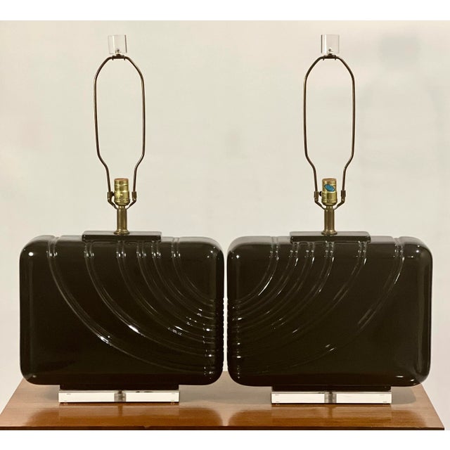 A gorgeous pair of oversized black glazed ceramic lamps from the 1980's. Each lamp features a continual, channeled wave...