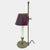 Antique brass bouillotte lamp. Demilune tole shade painted with a wood-like finish on an adjustable pole and acorn finial....