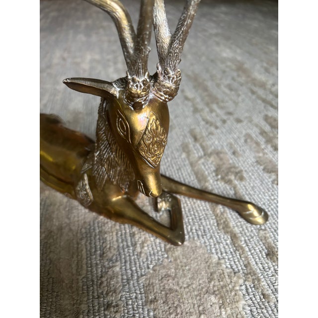 A solid brass reclining reindeer, probably dating from the 70's and possibly by Sarreid of Spain, adorned with diamond-...