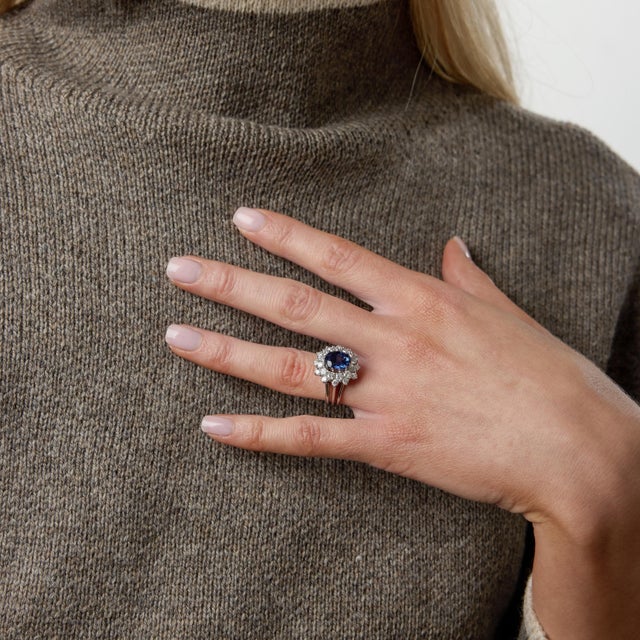 A luminous expression of 1950s elegance, this Mid Century cluster ring centers on a captivating 3.50 carat oval sapphire...