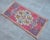 a Vintage Turkish Small yastik rug, red background rug perfect for entryway, bath or in front of the kitchen sink....
