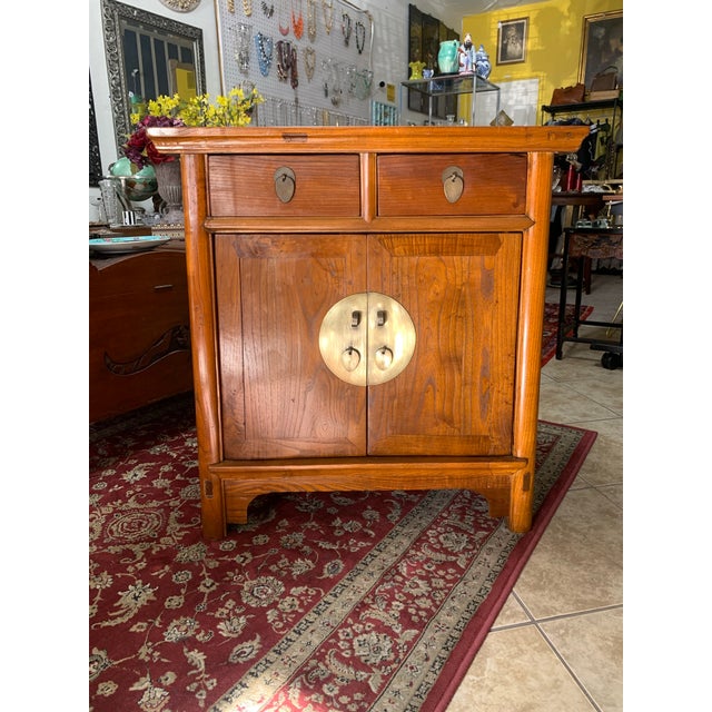 Beautiful vintage Asian-inspired solid wood cabinet featuring classic Ming-style design with a warm honey-toned finish and...