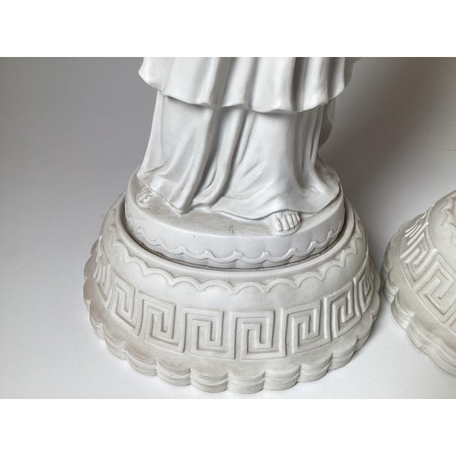 A Pair of Parian porcelain bisque neoclassical statues of a Greek couple. The original pair in white bisque finish with...