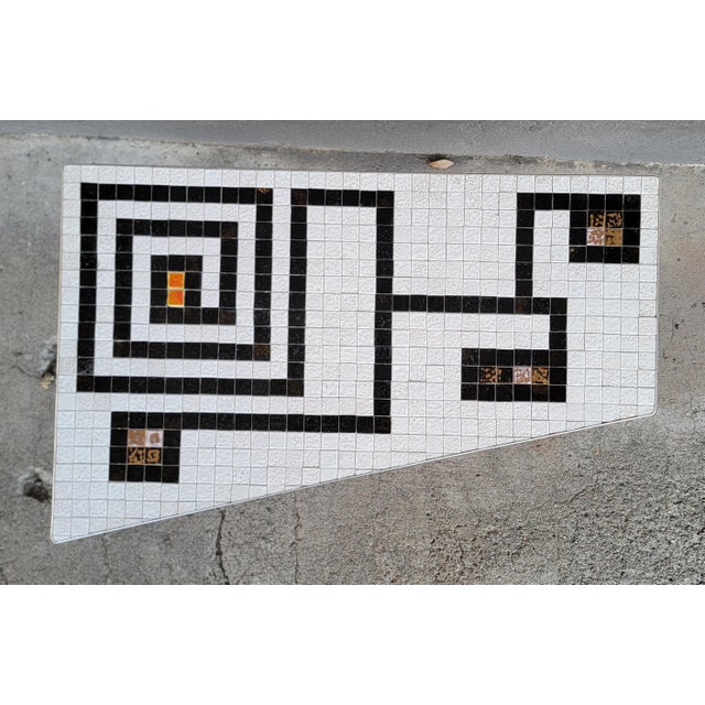 Asymmetrical mosaic tile coffee table with black and white geometric pattern. Conical metal legs painted black. aluminum...