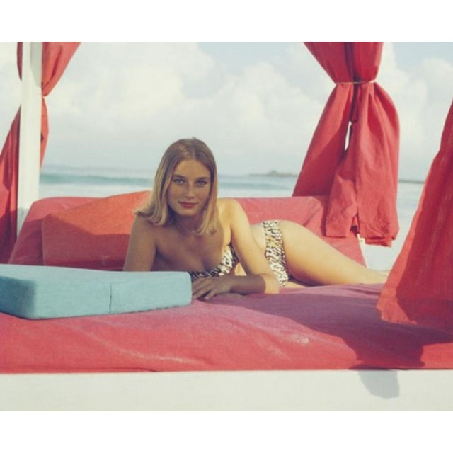 Tania Mallet 1961 By Slim Aarons 1961: Actress Tania Mallet relaxes on a red-curtained four poster in Eleuthera, in the...
