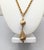 Goldtone textured round drop with conical filigree top with a textured rhodium ball above single pendant drop necklace...