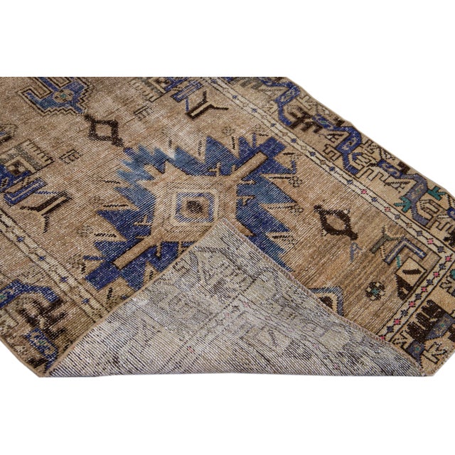 Beautiful Vintage Shabby Chic hand-knotted wool runner with a brown field. This runner has blue and beige accents all-over...