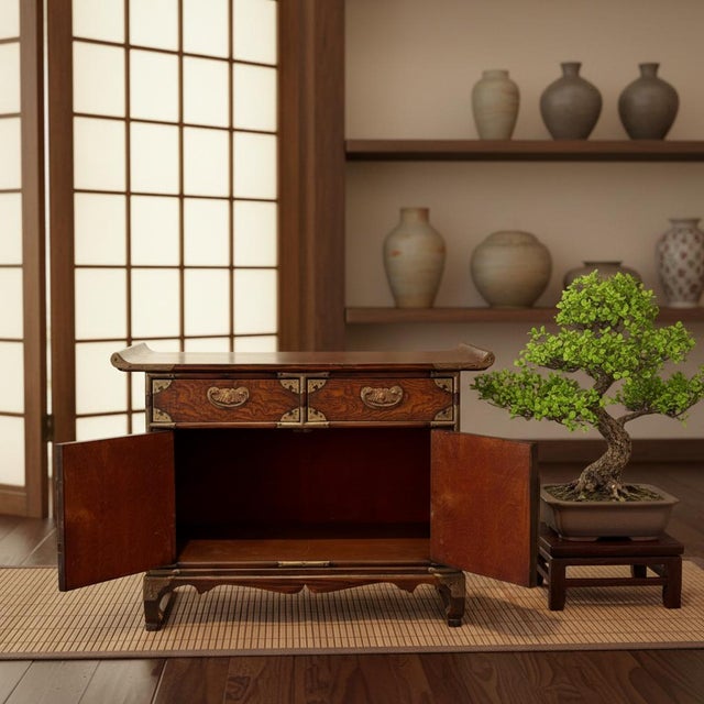 This antique Korean bandaji chest is crafted from solid hardwood, traditionally elm or pine, and fitted with elaborately...