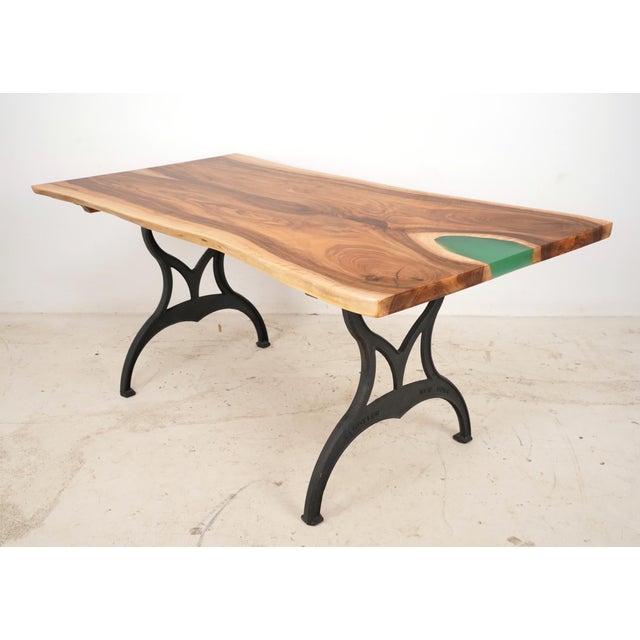 This table features a live edge slab walnut top with a blueish green epoxy resin pour on one end. The slab has been paired...