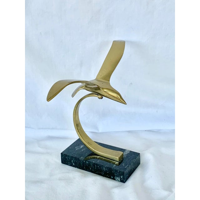 Fun vintage sculpture. Made of brass and stone. Features an abstract seagull. Perfect for display. Gives a coastal and...