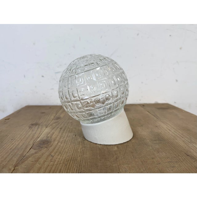 Vintage industrial light made in former Czechoslovakia the 1970s. It features a white porcelain wall mounting and a glass...