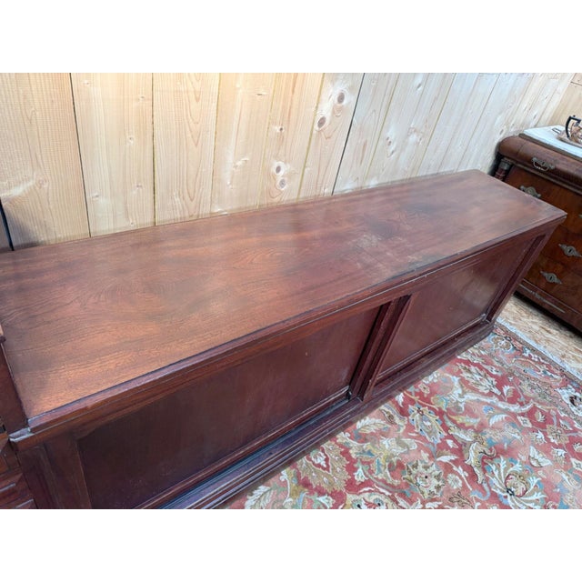 Large art deco style shop counter from the interwar period, made of solid mahogany-stained wood, originally designed for...