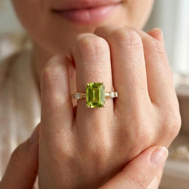 Discover the timeless elegance of this beautifully crafted ring. This piece centers on a striking 7x5mm emerald-cut...