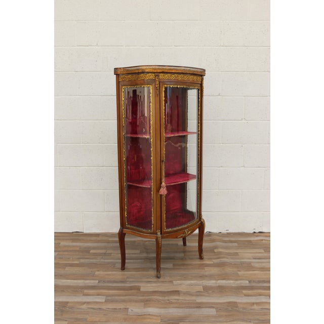 Beautiful 19th-century French Louis XV-style vitrine / curio cabinet featuring an elegant curved silhouette, ornate ormolu...