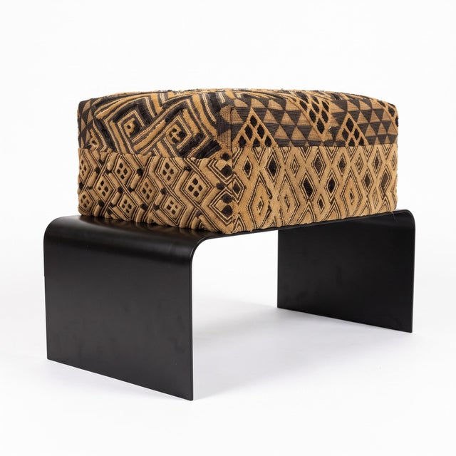 Handwoven Kuba cloth from the Democratic Republic of the Congo covers this contemporary Key West bench by Outpost...