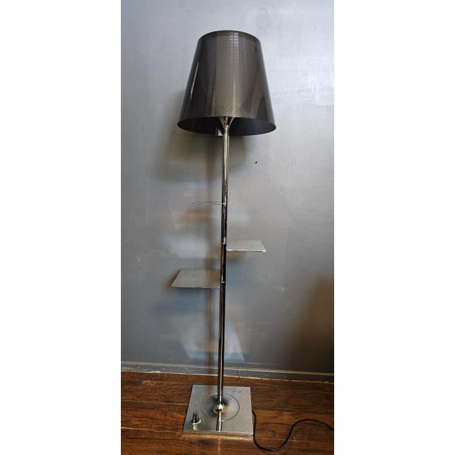 More than simply being a floor lamp, this object doubles as a bookshelf thanks to stainless steel lamellas jutting out of...