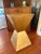 This contemporary pedestal features a bold double-pyramid silhouette finished in luminous antique gold on metal. Its...