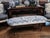 Custom upholstered chinoiserie-style bench featuring dramatic blue and white porcelain-inspired textile upholstery on a...
