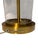 A refined pair of Ralph Lauren table lamps featuring clear cylindrical glass bodies with polished brass bases and center...