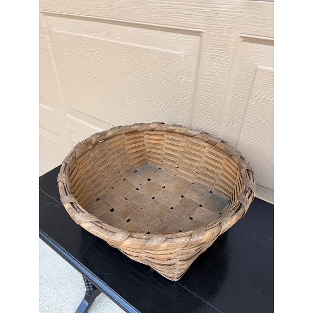 A beautifully woven early 20th century American splint oak basket with warm honeyed tones and a tightly constructed...