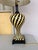 This lamp is a table lamp featuring a black and yellow "tumbling block" or chevron geometric pattern. Featuring a distinct...
