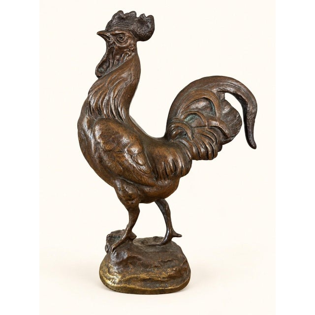 A proud Gallic rooster, immortalized in bronze, head held high, wings slightly spread, tail falling in a generous plume....