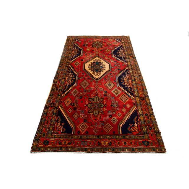 This Vintage all-over Designed wool rug has a field in red and navy blue. This piece has multicolor accents. This rug...