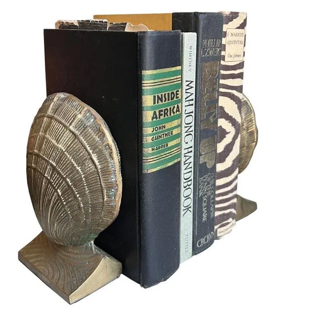 A pair of two solid brass clam shell bookends. This set would be wonderful on a desk, bookshelf, or dressing table....