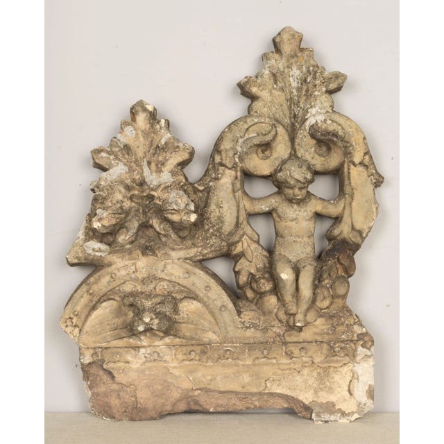 A set of twelve 19th century French terra cotta ornamental garden tiles. Very large detailed casting of cupid with foliate...