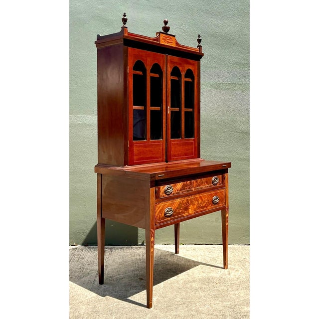 Exuding timeless Hepplewhite sophistication, this vintage secretary desk is crafted from richly grained wood and...
