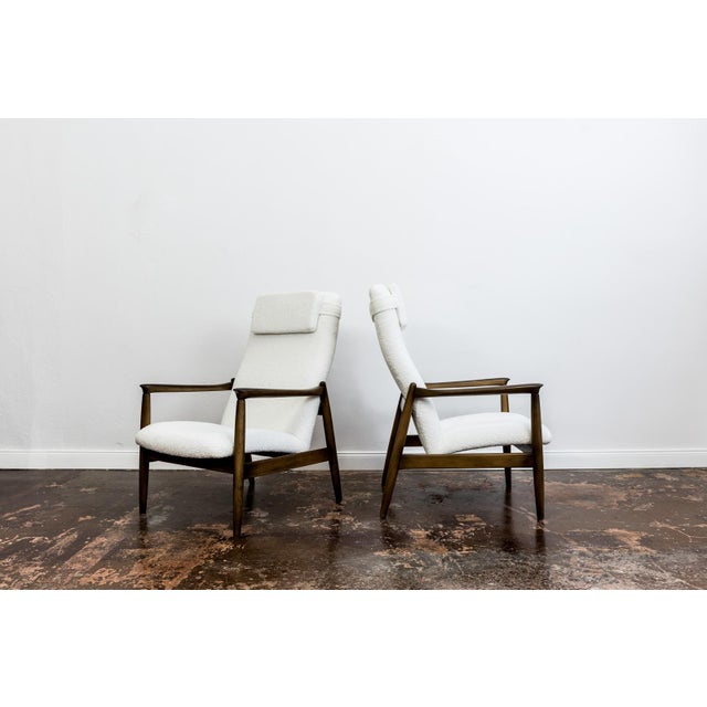 A pair of GFM-64 armchairs in a high-back version, designed by Edmund Homa, manufactured at the Gościcińska Furniture...
