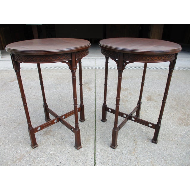 A stunning pair of round mahogany Chippendale style side tables. This pair of tables features beautiful woodgrain tops,...