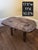 Beautiful hand hewn thick wood stool with four legs and rough cut surfaces.
