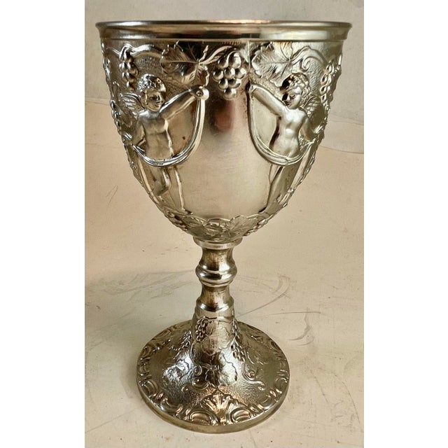 This is a very decorative single silver plate stem with an raised pair of cherubs draping a ribbon around what could be an...