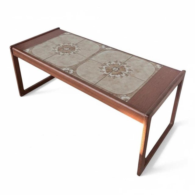 This mid-century coffee table features a distinctive tile top table design, combining floral ceramic tiles and a warm...