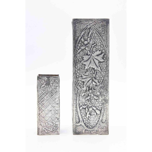 Set of 2 pewter vases realized in the early 20th century. Smaller pewter vase dimensions : h 10.7 x l 4.5 x l 4.5 cm....