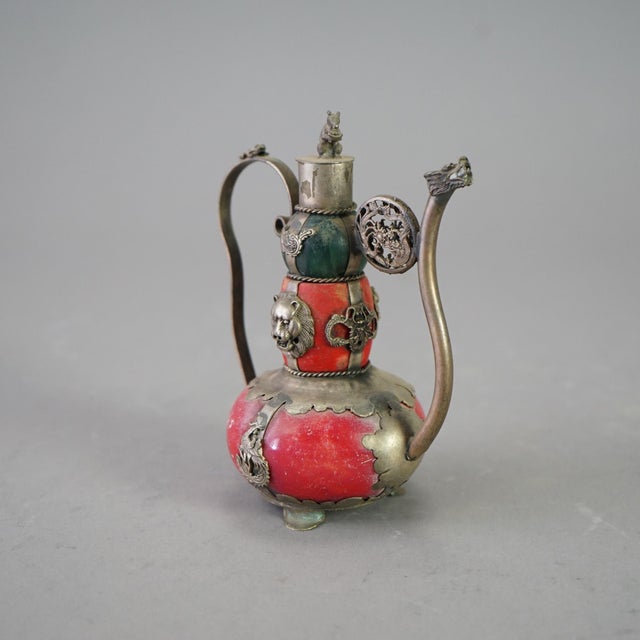 A miniature Chinese teapot offers porcelain vessel in double gourd form with silver-tone overlay with dragons, frogs, and...