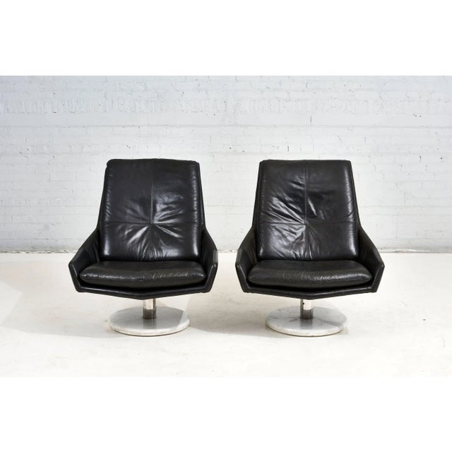 Pair black leather lounge chairs on stainless steel and Calacatta marble bases, circa 1970’s. Very good original condition.