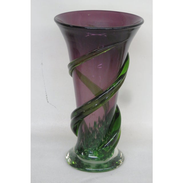 This lovely Vase is made out of hand blown glass. This unique vase features a purple and green color wrapped around the...