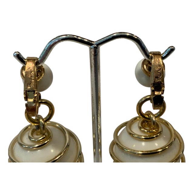 Goldtone and white balls spiral clip back. The earrings are marked Trriari. These earrings are from the Parisphere...