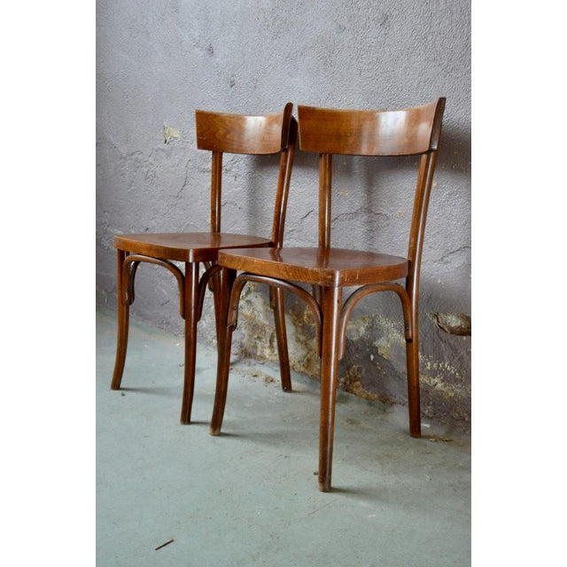 Simple but timeless lines, and deep, very patinated wood, here is a pair of vintage bistro chairs. They will easily...