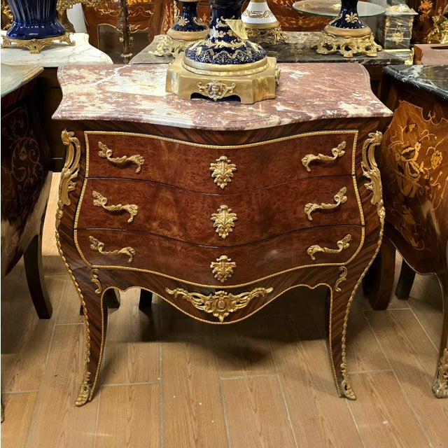 Make a statement with this magnificent French bombe commode, showcasing exceptional floral marquetry, graceful serpentine...