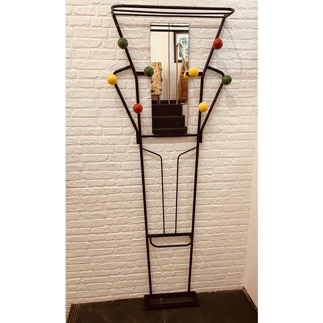 A vintage freestanding coat, luggage, and umbrella stand in black lacquered metal with 8 alternate colour wooden spheres...