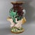 Minton Majolica vase which features three merboys supporting a vessel adorned with seaweeds. The rim of the vase is...