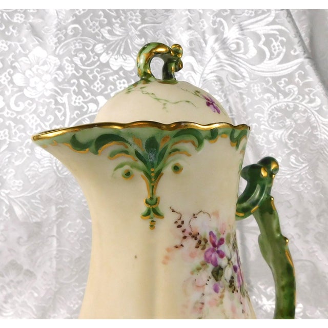This is a cream color matte finish Jean Pouyat Limoges chocolate pot with a matching lid. It has a light and dark green...
