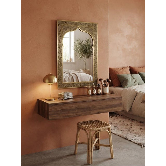 A handmade Moroccan decorative mirror with a natural yellow brass frame and traditional arabesque engraving. The frame is...