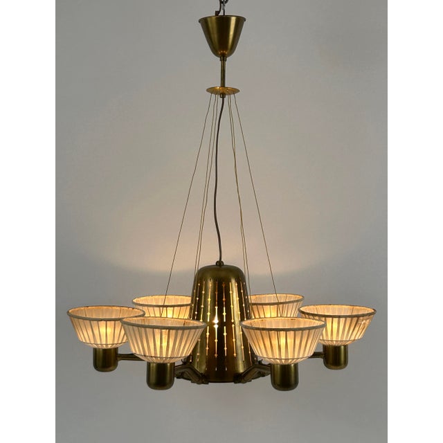 Extremely rare, lovely and highly decorative mid-century modern six-armed and seven flamed. Brass chandelier. Designed by...