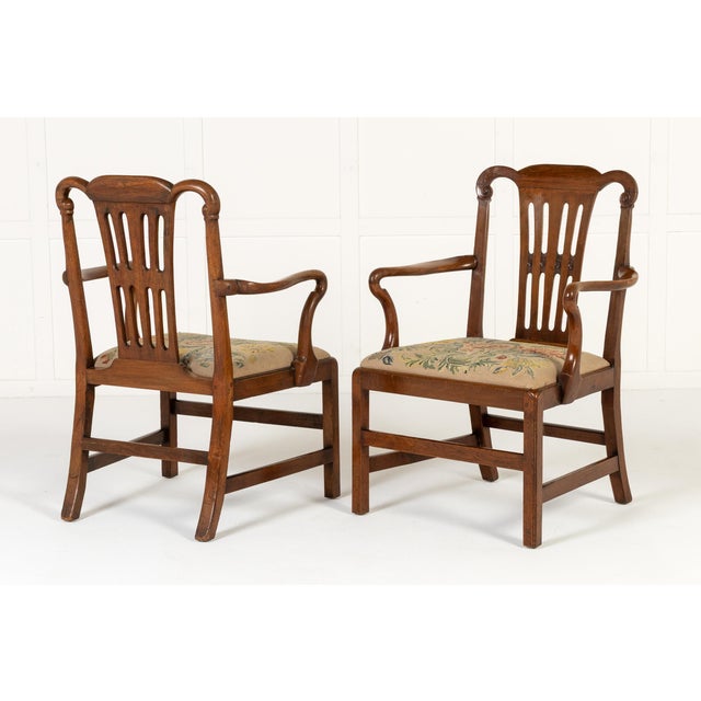 A handsome pair of late 18th century english mahogany armchairs of unusually generous proportions, each with a shaped...