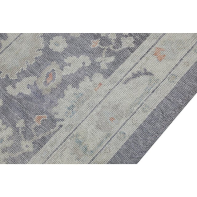 This modern Turkish Oushak rug is a stunning piece of art that has been handwoven using traditional techniques by skilled...